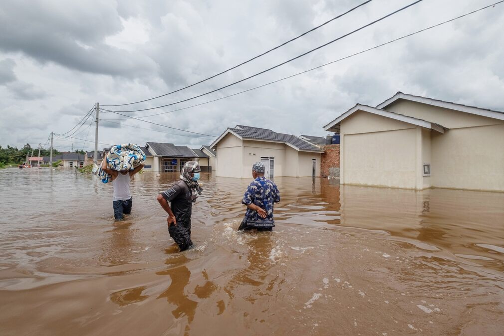 Some residents of Peknabaro, Indonesia, are trying to salvage their property after their homes were flooded after heavy rains on March 29, 2021.