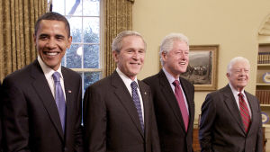 Four of the former Presidents of the United States in a row.  Jimmy Carter, Barack Obama, George W. Bush and Bill Clinton