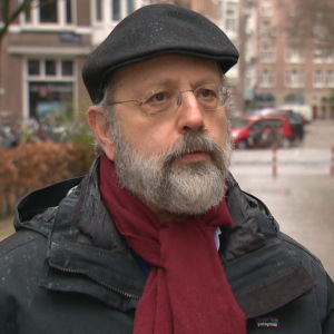 Professor Jonathan Zeitlin.  He is a middle-aged man.  The photo was taken outdoors.  It's still early spring in Amsterdam and it's raining. 