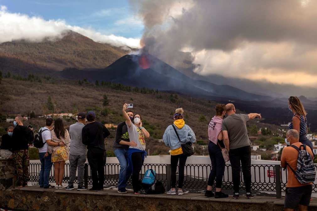 Tourists take selfies overlooking the volcanic eruption in La Palma.
